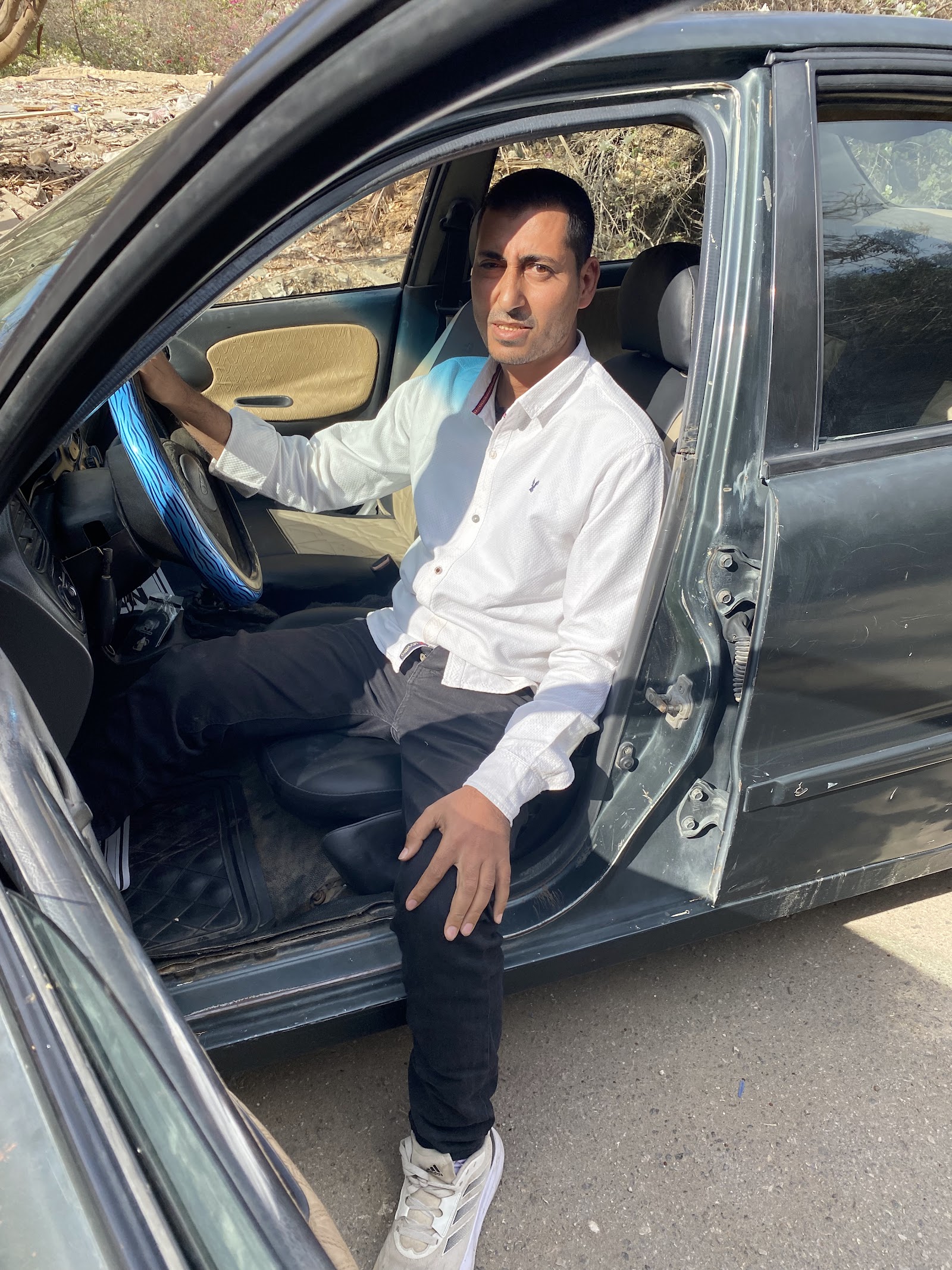 Ahmed seated in his newly purchased car