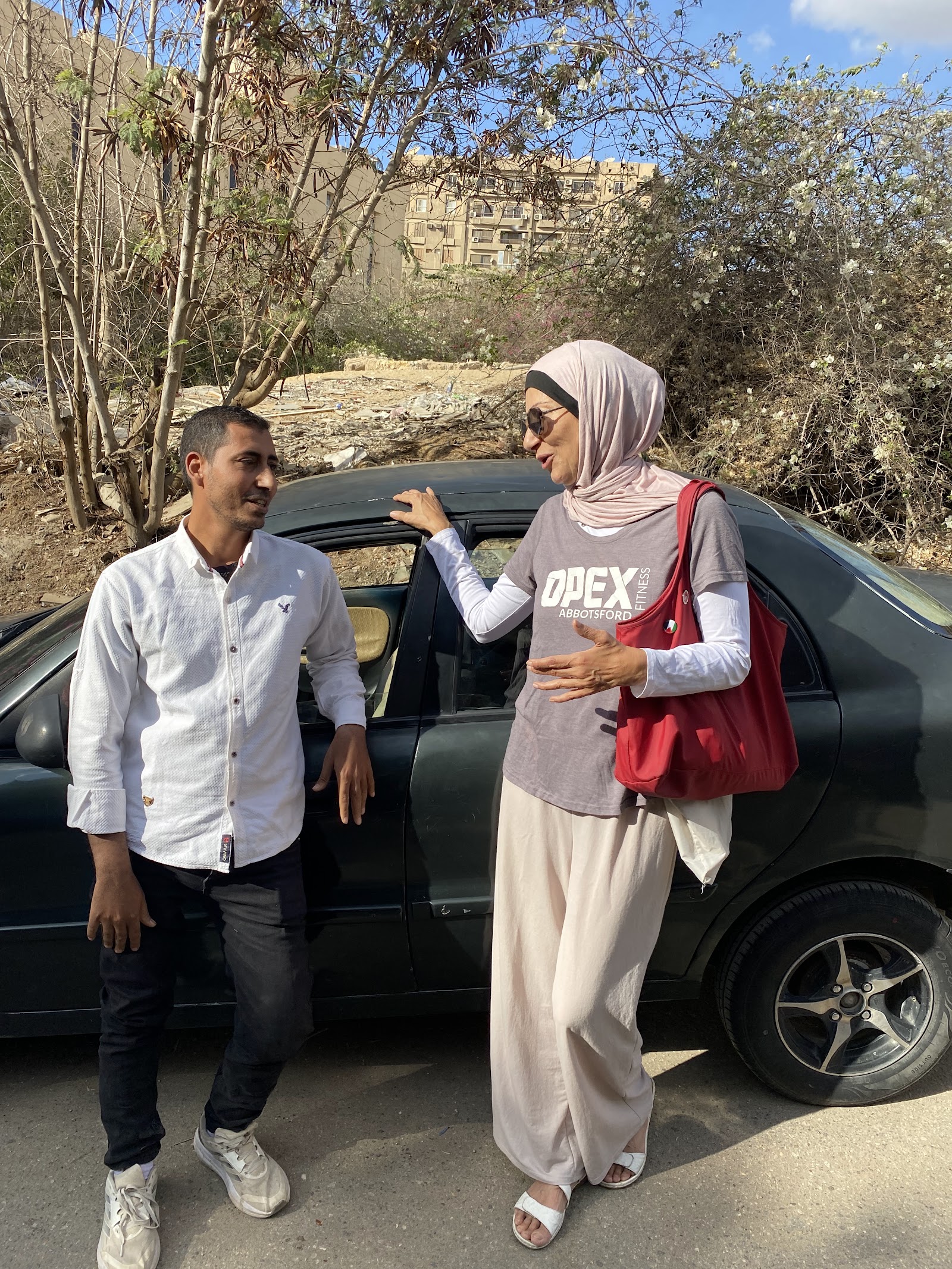 Ahmed speaking with Nehal beside the car